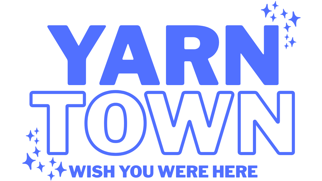 blue and white logo that says "Yarn Town, Wish you were here" with blue stars accenting the words